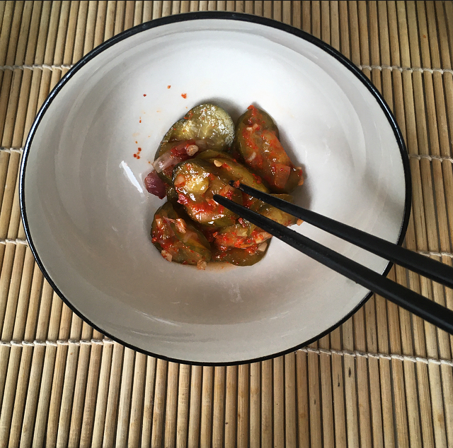 cucumber kimchi in a bowl with chopsticks